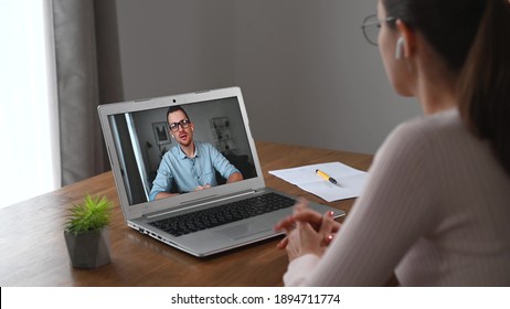 Online interview concept. Side view a female is has online video meeting with a pleasant young man on a laptop screen. A confident woman is talking, an applicant is listening and nods - Shutterstock ID 1894711774