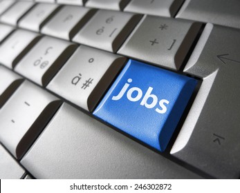 Online Job Search Concept With Jobs Sign And Symbol On A Blue Laptop Computer Key For Website And Online Business.