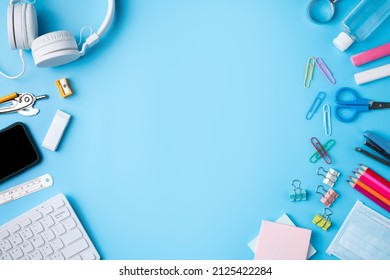 Online learning and back to school design concept. Top view of student table with headphone and stationery on blue table background. - Shutterstock ID 2125422284