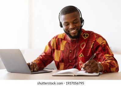 Online Learning. Black Man In African Clothes Study With Laptop At Home