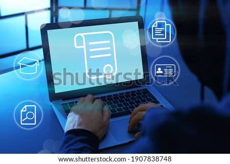 Online learning concept. Man using laptop with diploma illustration on screen surrounded by different icons, closeup