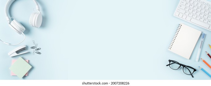 Online learning design concept. Top view of student table with computer, headphone and stationeries on blue table background. - Shutterstock ID 2007208226