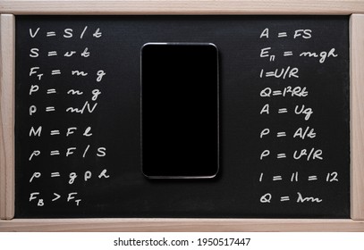 Online learning, math classes. Tablet on the background of a class board with written mathematical formulas