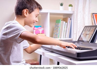 Online Learning, Remote Education. Boy Watching Video At Digital Tablet Computer And Having Fun Playing Piano And Singing At Home