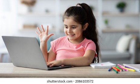 Online Lesson. Cute Little Schoolgirl Making Video Call With Laptop At Home, Smiling Preteen Female Child Waving Hand At Webcamera, Greeting Teacher During Distance Learning Class, Closeup