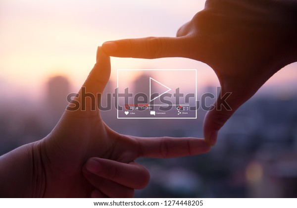 Online live video\
marketing concept.Photo sign made by human hands on blurred sunset\
sky as background