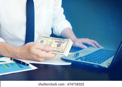 Online Loan Concept. Manager Is Holding Money In A Hand And Laptop. 