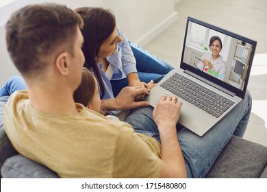 Online medical consultation for family patients. Doctor woman video call using laptop talks with family sitting on the sofa at home. - Powered by Shutterstock