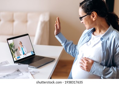 Online medical consultation. Mixed race adult pregnant woman talks with a female doctor by video call uses laptop, getting medical consultation, receives answers to questions and recommendations
