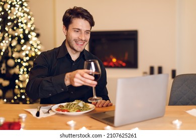 Online Meeting. Happy Handsome Man Making Video Call With Friends Or Wife During Dinner, Drinking Red Wine And Toasting To Screen, Sitting At Dining Table, Eating Pasta, Celebrating Alone At Home