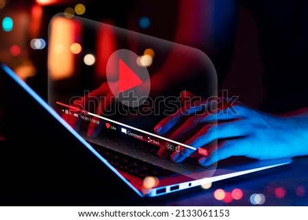 Online movie streaming with laptop computer, Young man watching a movie on a mobile phone with an imaginary video player service.