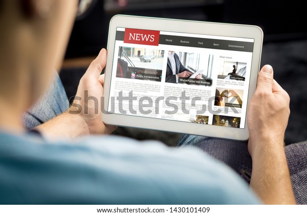 Online news article on tablet screen. Electronic\
newspaper or magazine. Latest daily press and media. Mockup of\
digital portal and website. Happy person using web service in the\
morning. Reading text.