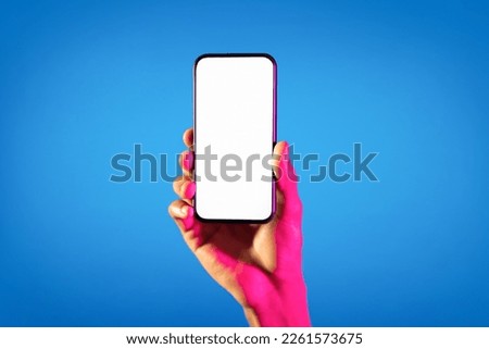 Online offer. Unrecognizable black man hand holding brand new smartphone with white empty screen over blue studio background in neon light, mockup for advertisement, copy space