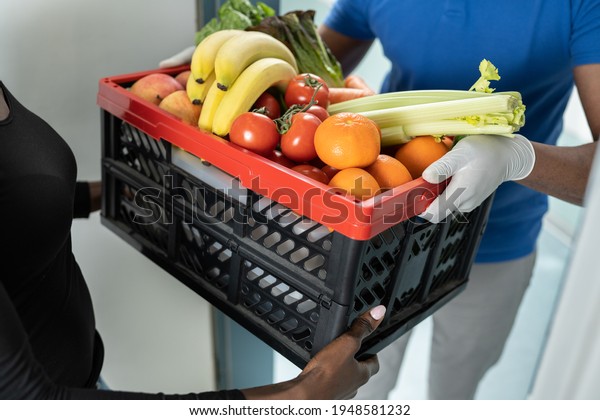 Online Order Food Delivery. African Man With\
Grocery Crate