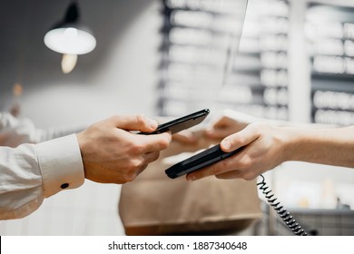 online payment. Sells takeaway food to a customer. Phone in hand for shopping in a cafe - Shutterstock ID 1887340648
