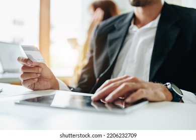 Online Payment And Shopping, A Male Businessman Uses A Credit Card To Swipe For A Discount Using A Tablet To Select Products.