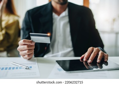 Online Payment And Shopping, A Male Businessman Uses A Credit Card To Swipe For A Discount Using A Tablet To Select Products.