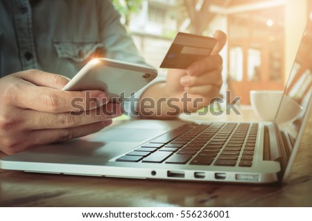 Online payment,Man's hands holding smartphone  and using credit card for online shopping.