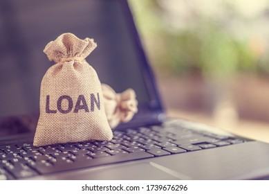 Online personal loan, financial concept : Loan bags on a laptop, depicting peer-to-peer lending, the practice of lending money to individual or business via online service among lenders and borrowers