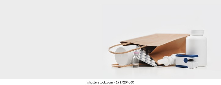 Online Pharmacy. Prescription Drugs And Over The Counter Medication Ready For Delivery To Customers. Pills And Spray White Mockup Containers And Buff Paper Bags Over The Laptop With Pulse Oximeter