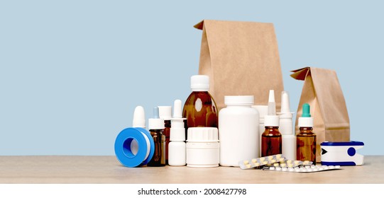 Online pharmacy. prescription drugs and over the counter medication ready for delivery to customers. Pills and spray white mockup containers and buff paper bags on table. Drugstore shopping - Shutterstock ID 2008427798