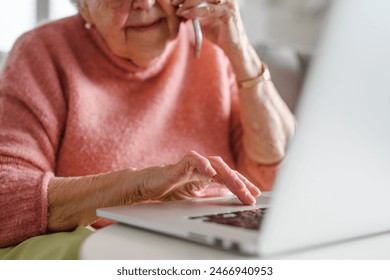 Online and phone scams targeting seniors. Scammer sending email to elderly woman, asking for money, demanding personal, sensitive informations without verification. - Powered by Shutterstock