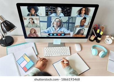 Online Remote High School Class Concept. Mixed Race College Student Distance Learning At Home On Desk Using Computer Conferencing With Teacher And Classmates Group Virtual Meeting On Screen. Top View