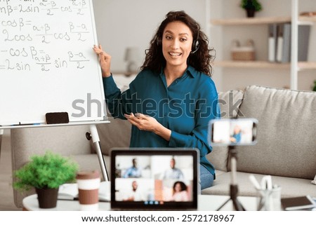 Online Remote Learning. Professor in headset having video conference chat with students and class group using pc and cellphone on tripod, teaching from home during quarantine and covid outbreak