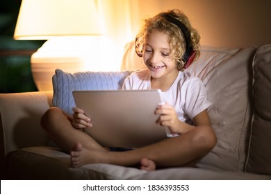 Online remote learning. School kid with computer and headphones at video conference chat with teacher and class group. Child studying from home. Little boy with laptop and tablet. Coronavirus outbreak