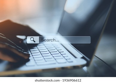 Online searching concept with human hands typing on laptop keyboard and search and navigation bar