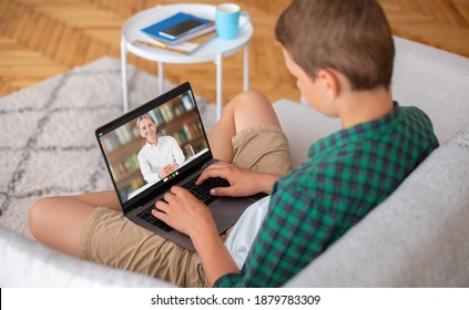 Online Secondary Education Concept. Teenager Using Laptop To Talk To School Teacher From Home. Teen Boy Having Video Call With Tutor, Participating In Online Lesson Or Webinar