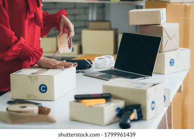 Online Seller Works At Home Office And Packs Shipping Delivery Box To Customer. Small Business Owner Or Entrepreneur Doing E-commerce Business On The Internet.