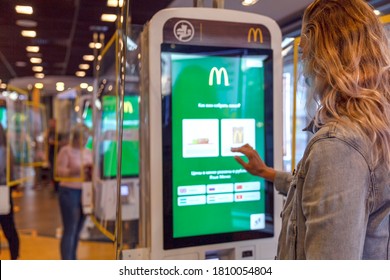 Online Service McDonald's Inside. The Girl Makes An Order By Touching The Monitor Screen. Moscow, Russia, 08/25/2020.