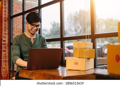 Online Shopping Asian Young Start Small Business In A Cardboard Box At Work. The Seller Prepares The Delivery Box For The Customer, Online Sales, Or Ecommerce.