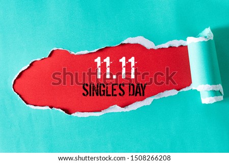 Online shopping of China, 11.11 single's day sale concept. Top view of green pastel torn paper and the text 11.11 single's day sale on a red background.