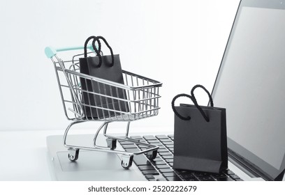 Online shopping concept. shopping cart with bags on laptop on white background. Black friday sale - Powered by Shutterstock