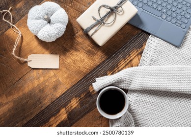 Online shopping concept, cyber-Monday, with keyboard, warm sweater, a mug of hot coffee, gift, tag, and a white pumpkin on a wooden background, copy space. - Powered by Shutterstock