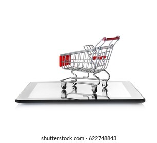 Online shopping concept. Tablet with mini market trolley on white background