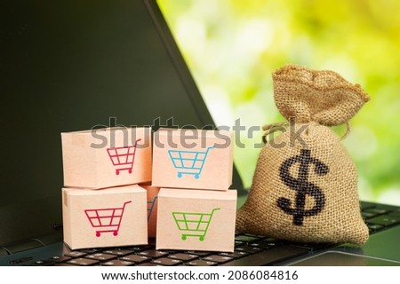 Online shopping and delivery service concept. Paper boxes in a shopping cart on a laptop keyboard, this image implies online shopping that customer order things from retailer sites via the internet