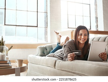 Online shopping, ecommerce and credit card with digital tablet by woman on a sofa, happy and relax. Online banking, debit card and girl checking credit score, savings or membership in a living room - Powered by Shutterstock