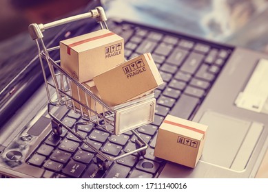 Online Shopping  E-commerce And Customer Experience Concept : Boxes With Shopping Cart On A Laptop Computer Keyboard, Depicts Consumers  Buyers Buy Or Purchase Goods And Service From Home Or Office