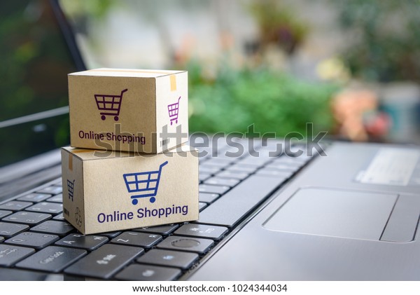 オンラインショッピング Eコマース デリバリーサービスのコンセプト ノートパソコンのキーボードにショッピングカートまたはトロリーのロゴが付いた紙箱 顧客が小売店のサイトからインターネットを通じて注文する様子を表します の写真素材 今すぐ編集