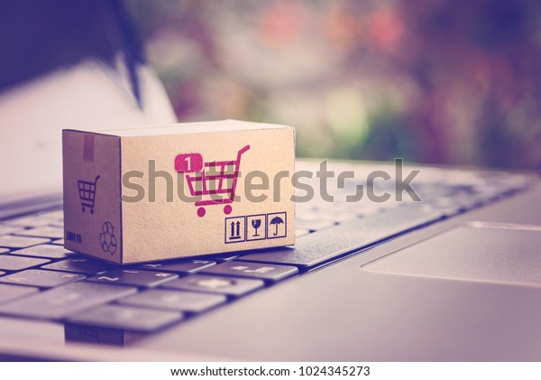 オンラインショッピング Eコマース デリバリーサービスのコンセプト ノートパソコンのキーボードにショッピングカートまたはトロリーのロゴが付いた紙箱 顧客が小売店のサイトからインターネットを通じて注文する様子を表します の写真素材 今すぐ編集