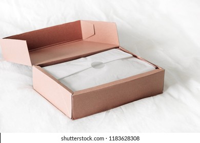 Online Shopping Fashion Items Opening Box On A White Background With Copy Space