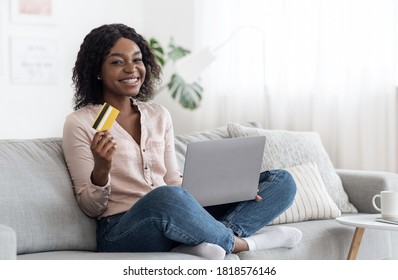 Online Shopping. Joyful African Lady Posing At Home With Laptop And Credit Card, Enjoying Purchase In Internet, Copy Space