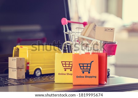 Online shopping, logistics, supply chain and shipment service, e-commerce concept : Paper bags, boxes of goods, trolley, delivery van on a laptop, depicts customers uses internet to order  buy things