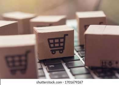 Online Shopping - Paper Cartons Or Parcel With A Shopping Cart Logo On A Laptop Keyboard. Shopping Service On The Online Web And Offers Home Delivery.