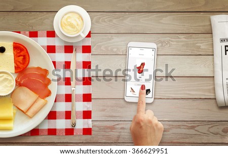 Online shopping with smart phone with woman hand during breakfast.