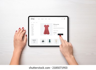 Online shopping with a tablet. Red women's dress on the e-commerce web page - Shutterstock ID 2185071903