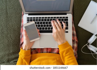 Online Shopping, Top View Work At Home. Woman Typing Code And Password From Message On Phone On Laptop. Security On The Internet